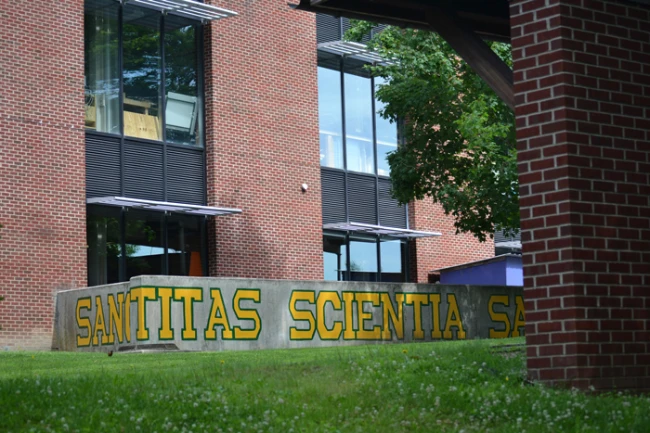 an L-shaped wall with a painting of the latin words, Sanctitas, Scientia, Sanitas.