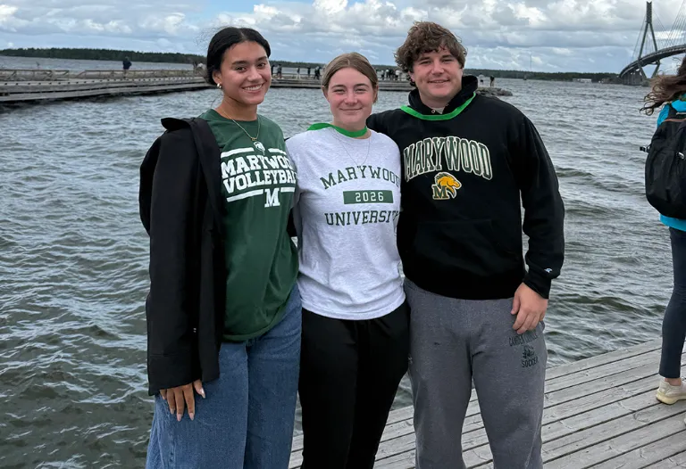 three marywood students with a body of water behind them