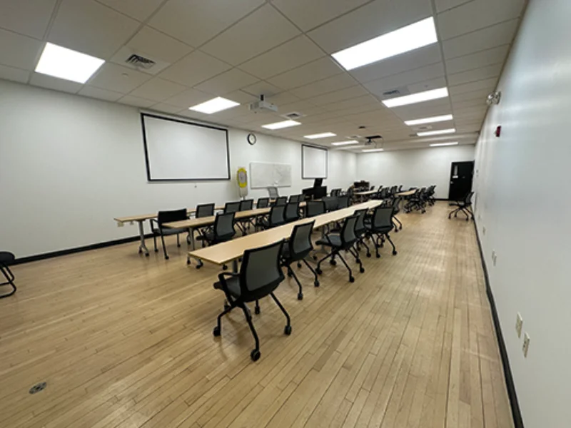 a business classroom in the visual arts center with long skinny tables and rolling chairs