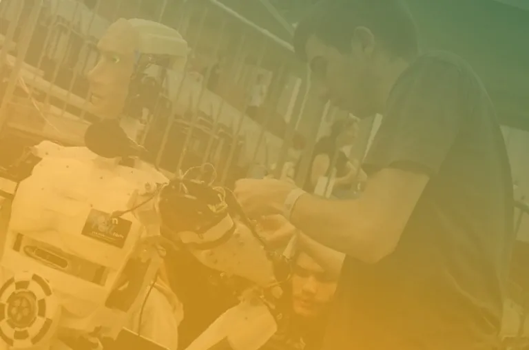 ombre green and gold filter over a man working on an animatronic robot