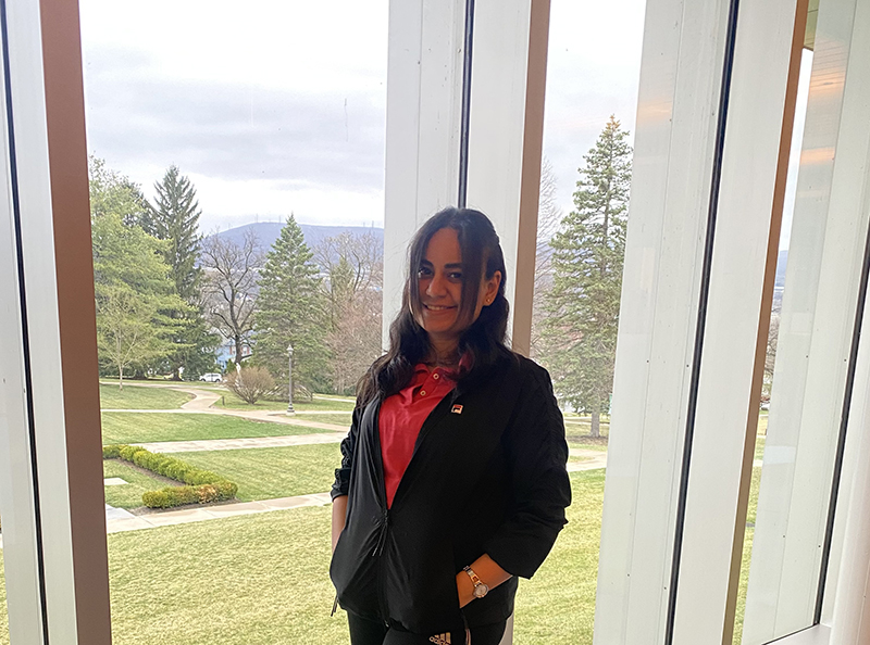 girl posing in front of window with trees in background