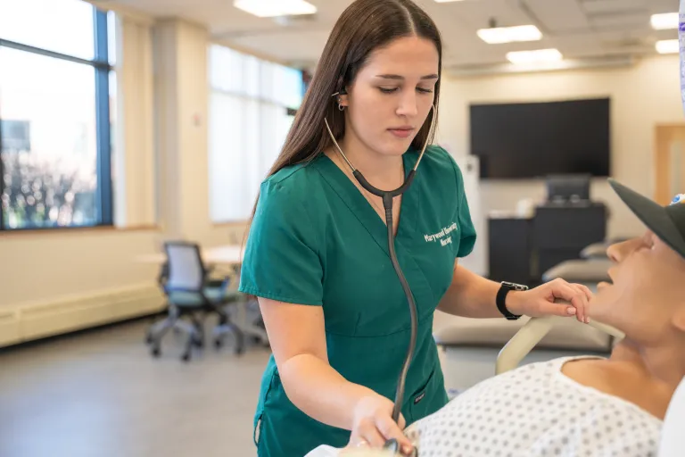 Female nursing student practices the use of a  stethoscope